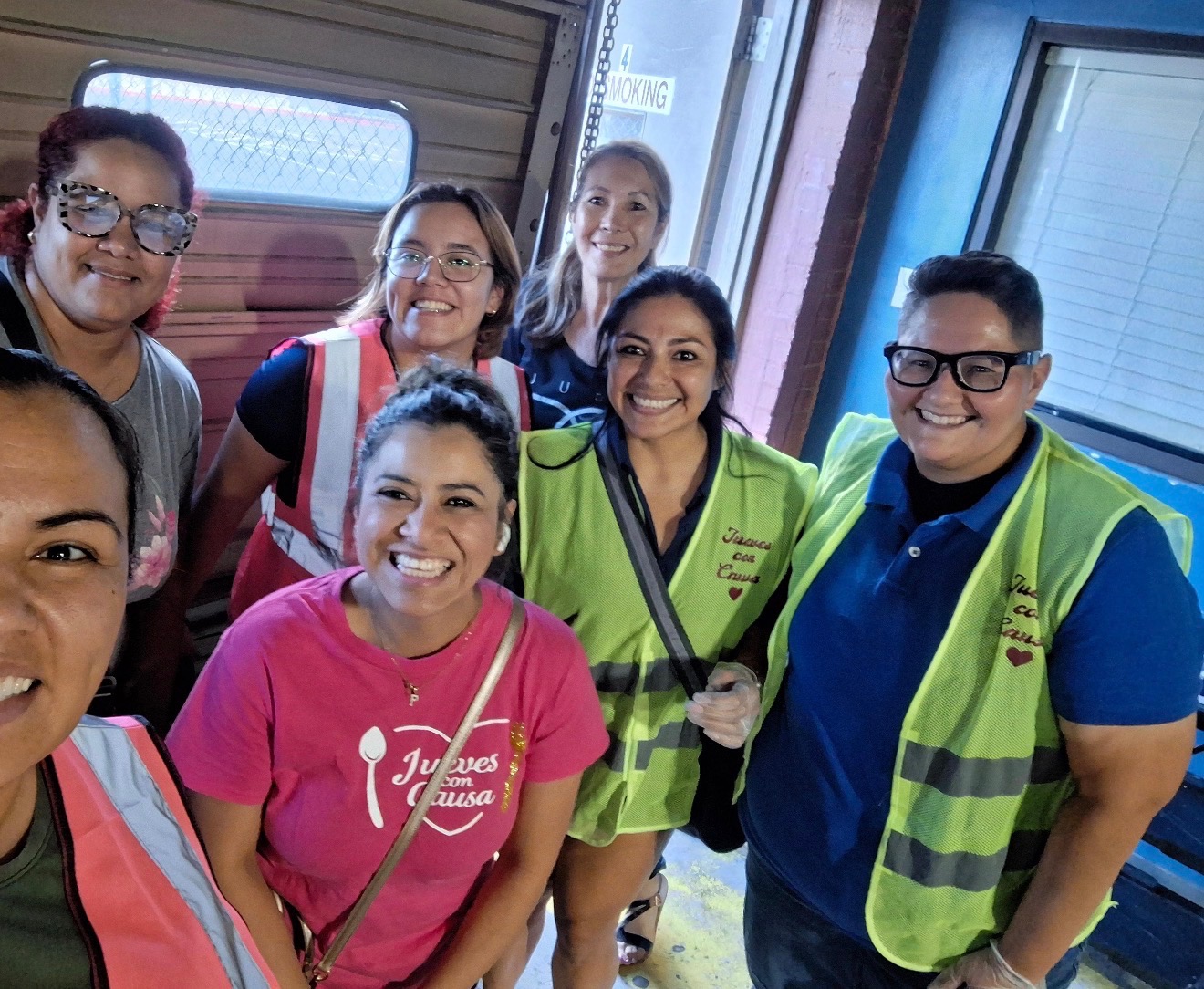 Jueves Con Causa volunteer team smiling together before serving meals